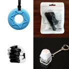 A collage of four blue and black sensory toys from the 2 Chew Necklaces + 2 Fidget Toys Bundle: a blue star-shaped chew necklace, a black and white fidget toy in a sealed bag, a coiled black and white toy, and a cat paw keychain with a white base on a keyring.