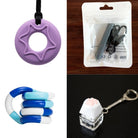 A collage showcasing the "2 Chew Necklaces + 2 Fidget Toys Bundle" includes a purple chew necklace, a black pendant in a clear plastic package, a twisted blue and white fidget toy, and a paw keyboard fidget keychain with a paw-shaped button.